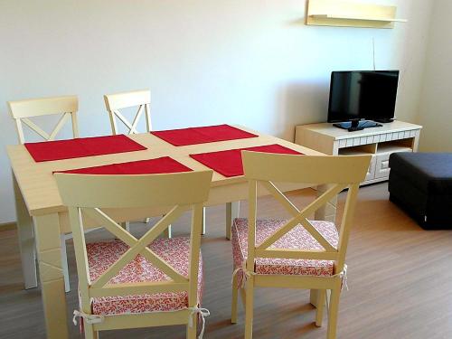 a dining room table with four chairs and a television at Apartmány Dalila in Rajecké Teplice