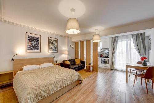 ein Schlafzimmer mit einem Bett und ein Wohnzimmer in der Unterkunft Bucharest Airport Suites & Villas in Otopeni