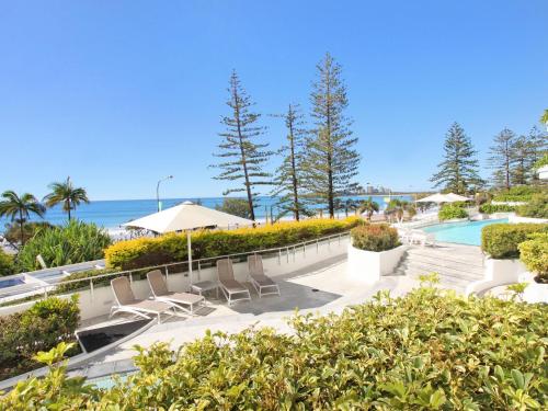 a resort with a pool and chairs and the ocean at Sirocco 202 in Mooloolaba