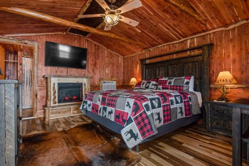 una camera con letto, camino e TV di Log Cabin Inn a Eureka Springs