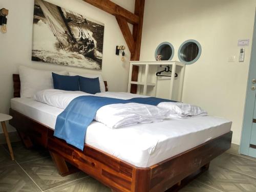 una camera da letto con un grande letto con lenzuola bianche e blu di Dunakavics Boutique Apartman Szentendre a Szentendre