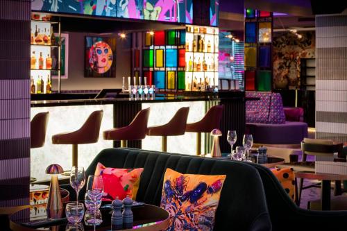 um restaurante com um bar com cadeiras e mesas em NYX Hotel London Holborn by Leonardo Hotels em Londres