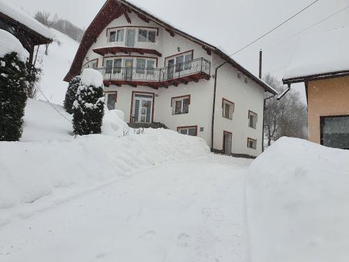 a house with a pile of snow in front of it at Casa Destinatia Perfecta in Braşov