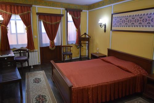 - une chambre avec un lit, une table et des chaises dans l'établissement Family Hotel at Renaissance Square, à Plovdiv