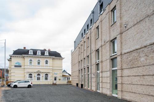 un coche blanco estacionado junto a un gran edificio de ladrillo en Villa Beachside, en Eckernförde