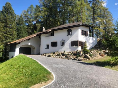 een wit huis op een heuvel met een oprit bij Chalet Chesa Surlej, Davos in Davos