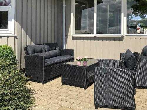 three wicker chairs and a couch on a patio at Two-Bedroom Holiday home in Aabenraa 2 in Aabenraa