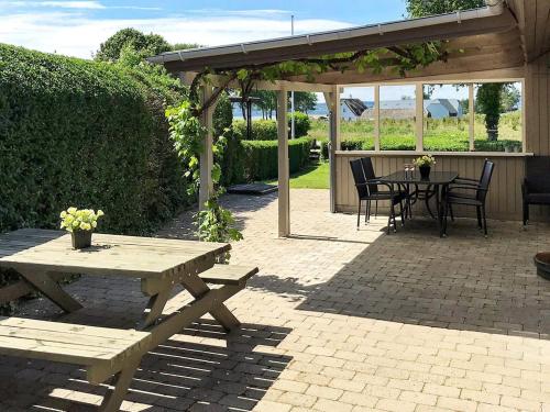 a patio with a picnic table and a table and chairs at Two-Bedroom Holiday home in Aabenraa 2 in Aabenraa