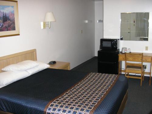 a bedroom with a bed and a desk and a television at Mecca Motel in Colorado Springs