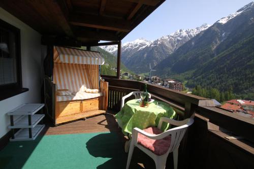 d'un balcon avec une table, des chaises et des montagnes. dans l'établissement Haus Sonnenhang, à Sölden