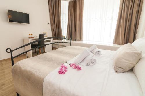 una camera da letto con un letto bianco e fiori di Via Domus a Spalato (Split)