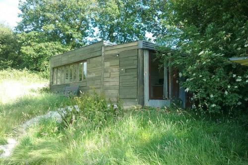 eine kleine Hütte inmitten eines Grasfeldes in der Unterkunft Stags View,Unique eco cabin, Dartmoor views in South Brent