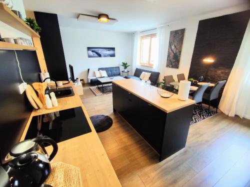 uma sala de estar com uma cozinha e uma sala de estar com um sofá em Apartman Loggia Park & Free Parking em Žilina