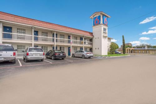 un hôtel avec des voitures garées devant un bâtiment dans l'établissement Motel 6-Dallas, TX - Market Center, à Dallas