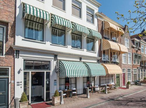 un bâtiment avec des auvents verts et blancs dans une rue dans l'établissement Boutique Hotel Huys van Leyden, à Leyde