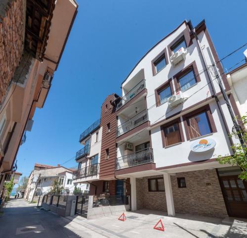 een hoog wit gebouw met balkons in een straat bij Blue Lake Apartments in Ohrid