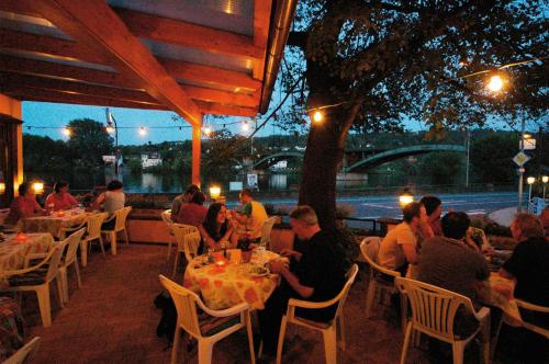 un groupe de personnes assises à une table dans un restaurant dans l'établissement Hotel Weinhaus Kreuter, à Coblence