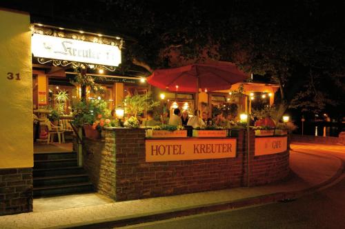 un hôtel avec des personnes assises dehors la nuit dans l'établissement Hotel Weinhaus Kreuter, à Coblence