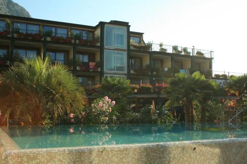 un hotel con piscina di fronte a un edificio di Hotel Alexander a Limone sul Garda