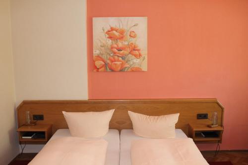 a bedroom with two beds and a painting on the wall at Landgasthof Heerlein in Bamberg