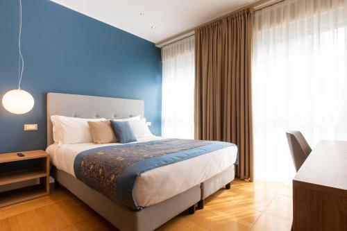 een slaapkamer met een bed en een blauwe muur bij Missori Suites in Milaan