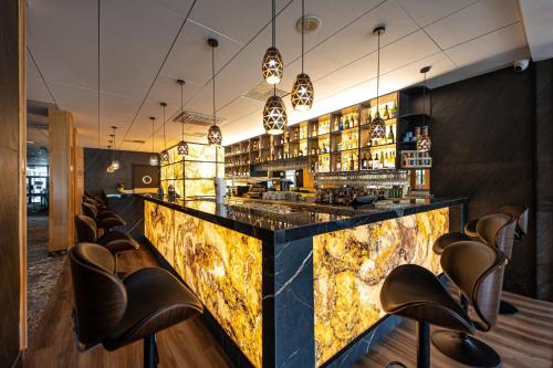 a lobby with a bar with leather chairs at Hotel Mrągowo Resort&Spa in Mrągowo