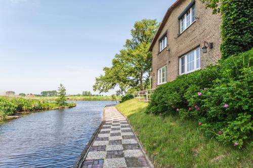 un edificio accanto a un fiume accanto a un edificio di Fährhauslodges Natur in Sicht a Norden