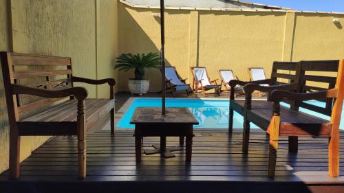 a patio with a table and chairs and a swimming pool at Pousada Búzios Garden in Búzios