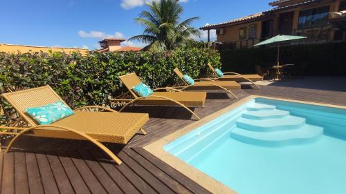 a row of chairs sitting next to a swimming pool at Pousada Búzios Garden in Búzios