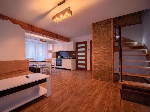 een woonkamer met een trap en een keuken bij Tatrzańska Kryjówka Premium Chalets Zakopane in Poronin