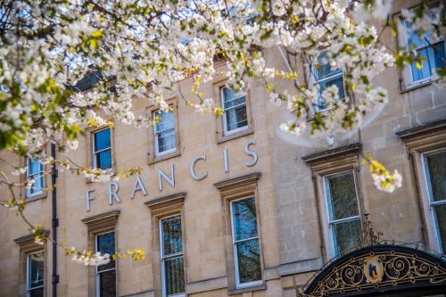 ein Schild an der Vorderseite eines Gebäudes mit weißen Blumen in der Unterkunft Francis Hotel Bath in Bath