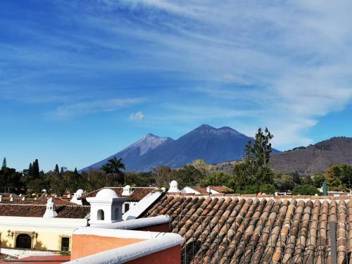 a view from the roof of a building with mountains in the background at Hotel Posada San Pedro in Antigua Guatemala