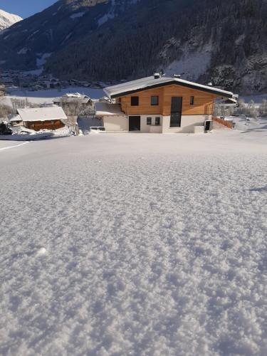 dom w środku pola śniegu w obiekcie Appartment Sonnenwiese w mieście Finkenberg