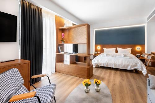 een slaapkamer met een bed en een woonkamer bij DAYS City Suites in Patra