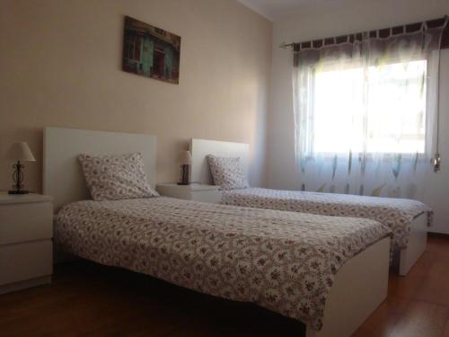 sypialnia z 2 łóżkami i oknem w obiekcie Spacious Central 2 Bedroom Apartment w mieście Setúbal