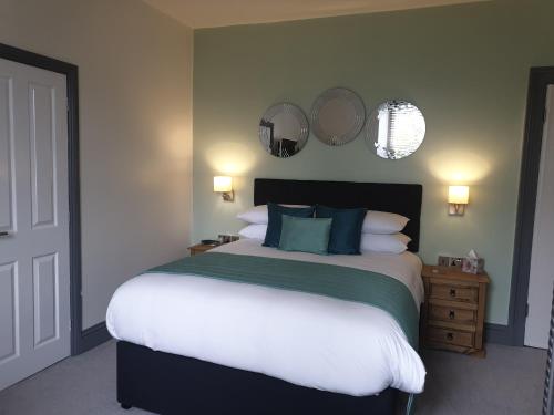 una camera da letto con un grande letto e due specchi sul muro di Compston House B & B ad Ambleside