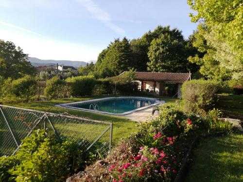 a garden with a swimming pool and a house at Casa De Fatauncos in Vouzela