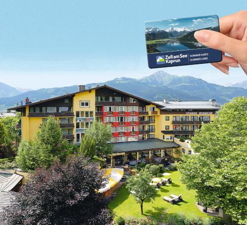 uma pessoa a tirar uma fotografia a um hotel em Hotel Latini em Zell am See