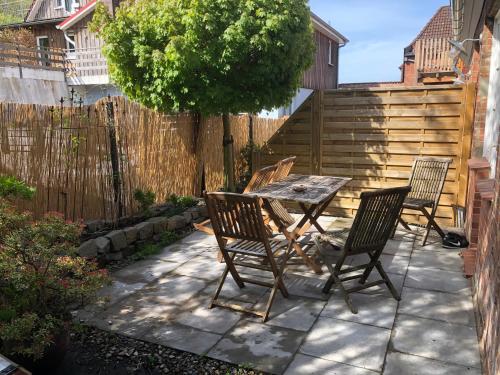 een patio met 4 stoelen, een tafel en een hek bij Kalkberg Ferienwohnungen in Bad Segeberg