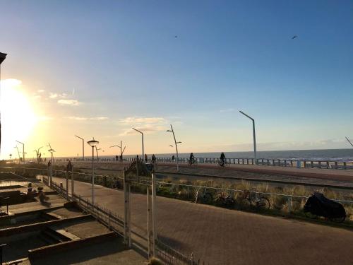 un tramonto su una spiaggia con molo e oceano di Sea view Scheveningen a Scheveningen