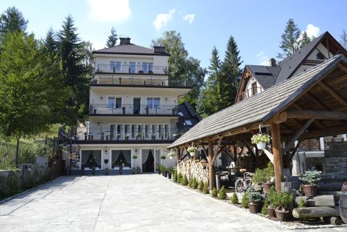 uma grande casa branca com um alpendre e um edifício em Willa Sepia SPA em Wisła