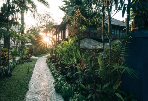 坎古Hotel Tugu Bali的一座花园,有房子和一些植物