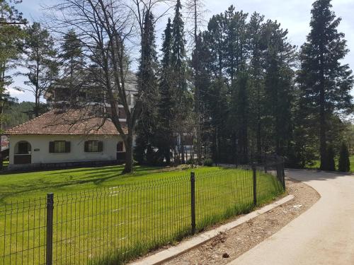 una cerca frente a una casa con un patio en SunStone Apartment, en Zlatibor