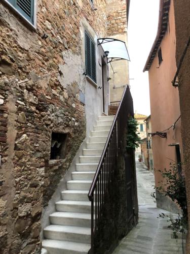 uma escada que conduz a um edifício com uma parede de pedra em LA CASA DI ZOE em Campiglia Marittima