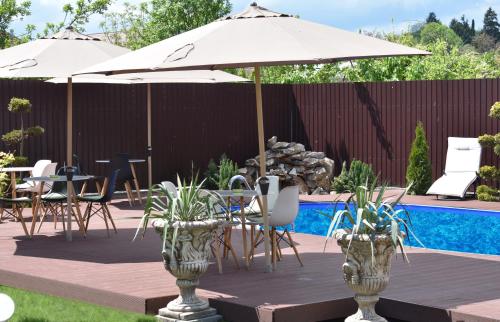 - une table et des chaises sous un parasol à côté de la piscine dans l'établissement Pensiunea Casa Zece, à Turda