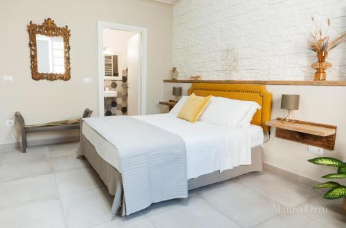 una camera con un grande letto e uno specchio di NEW HOME - appartamento in centro storico a Cagliari