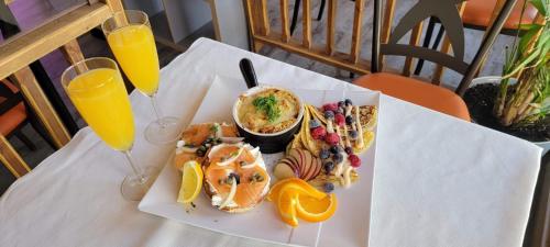 einen Tisch mit einem Teller Essen und zwei Gläsern Orangensaft in der Unterkunft Orange Bistro in Baie-Saint-Paul