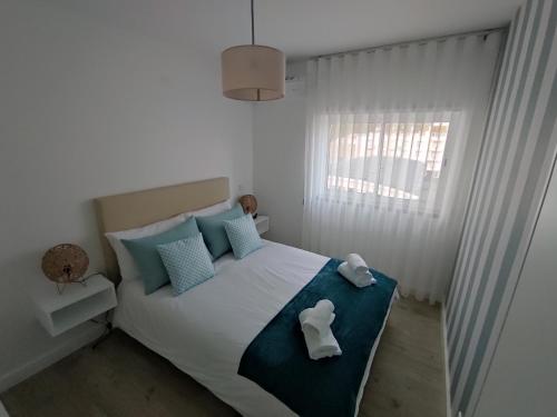 - une chambre avec un lit muni d'un oreiller pour chien dans l'établissement Beachfront Apartment Nazaré, à Nazaré