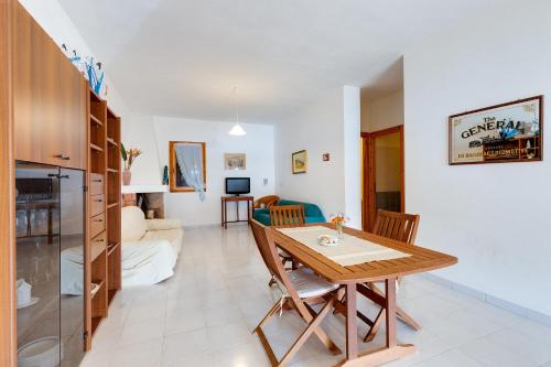 een eetkamer en een woonkamer met een tafel en stoelen bij La vista di Mondo in Torre Dei Corsari