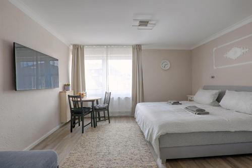 a bedroom with a bed and a table with chairs at H-Apartments Bismarckstrasse in Trier